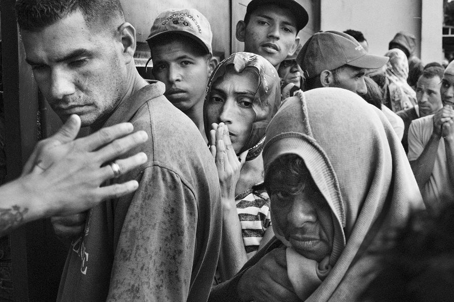 Migrants wait in line for a free meal at a church charity in Cucuta, Colombia.