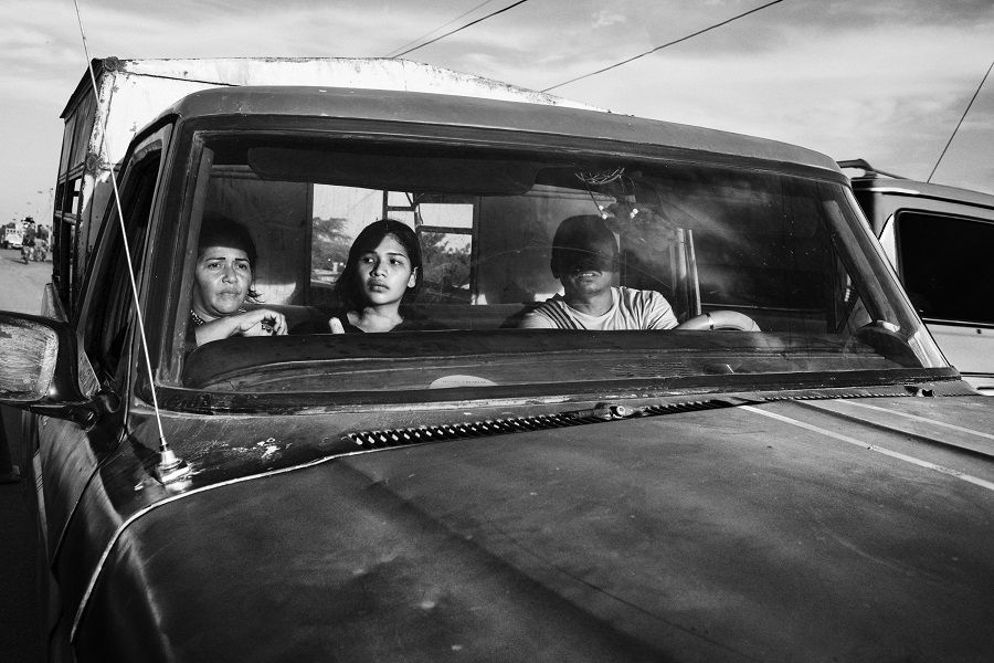 Migrants sit in a truck at the border town of Paraguachón, Colombia, waiting for a ride to the major city of Maicao.