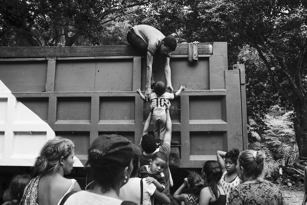 A group of migrants climb the wall of a truck to get a ride in the attempt to reach Bogotá from the border, Colombia.