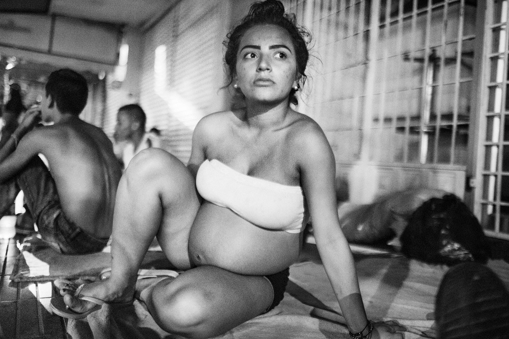 A Venezuelan girl, pregnant, sits in a street in Cucuta where she will spend the night with other migrants. Many Venezuelans enter Colombia to give birth since hospital conditions got worst in Venezuela and lack of medicines and doctors represents a risk for childbirths.